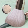 A close-up of a pink makeup brush with soft bristles, demonstrating its use for applying powder.