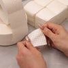 Hands are removing a white cotton pad from a box of professional cotton pads for nail and gel polish removal.