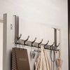 A modern silver over-the-door organizer rack with extended arms mounted on a light gray wooden panel.