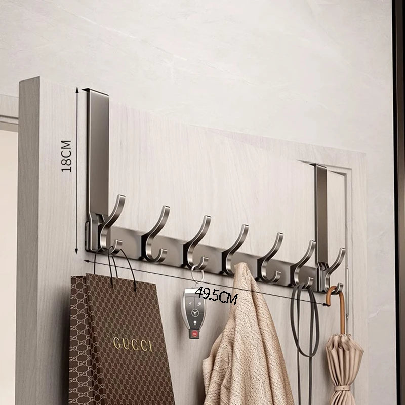 A modern silver over-the-door organizer rack with extended arms mounted on a light gray wooden panel.