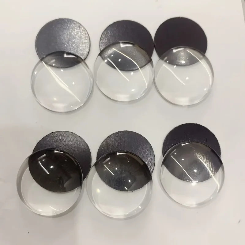 A set of decorative glass refrigerator magnets in various shades of gray and black.