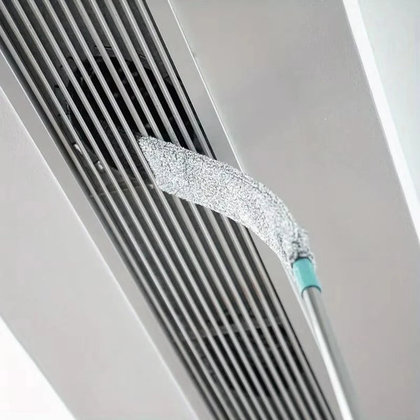 Nahaufnahme eines silbernen Mikrofasertrockners und Reinigungsbürsten-Sets, befestigt an einem Metallrohr oder Lüftungsgitter