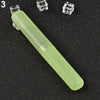 A light green, elongated travel and storage toothbrush case with clear protective covers is shown on a dark surface.