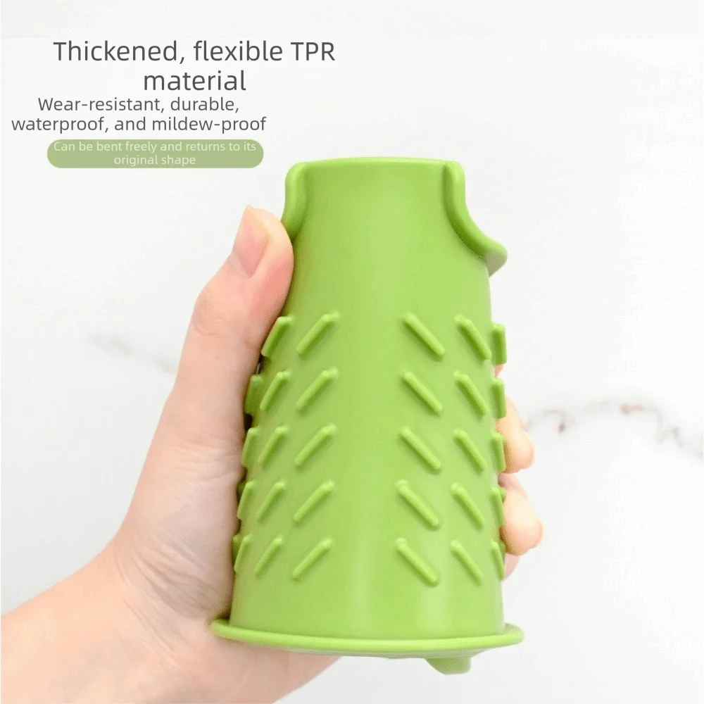 A hand holds a bright green silicone sink splash guard drip catcher mat.