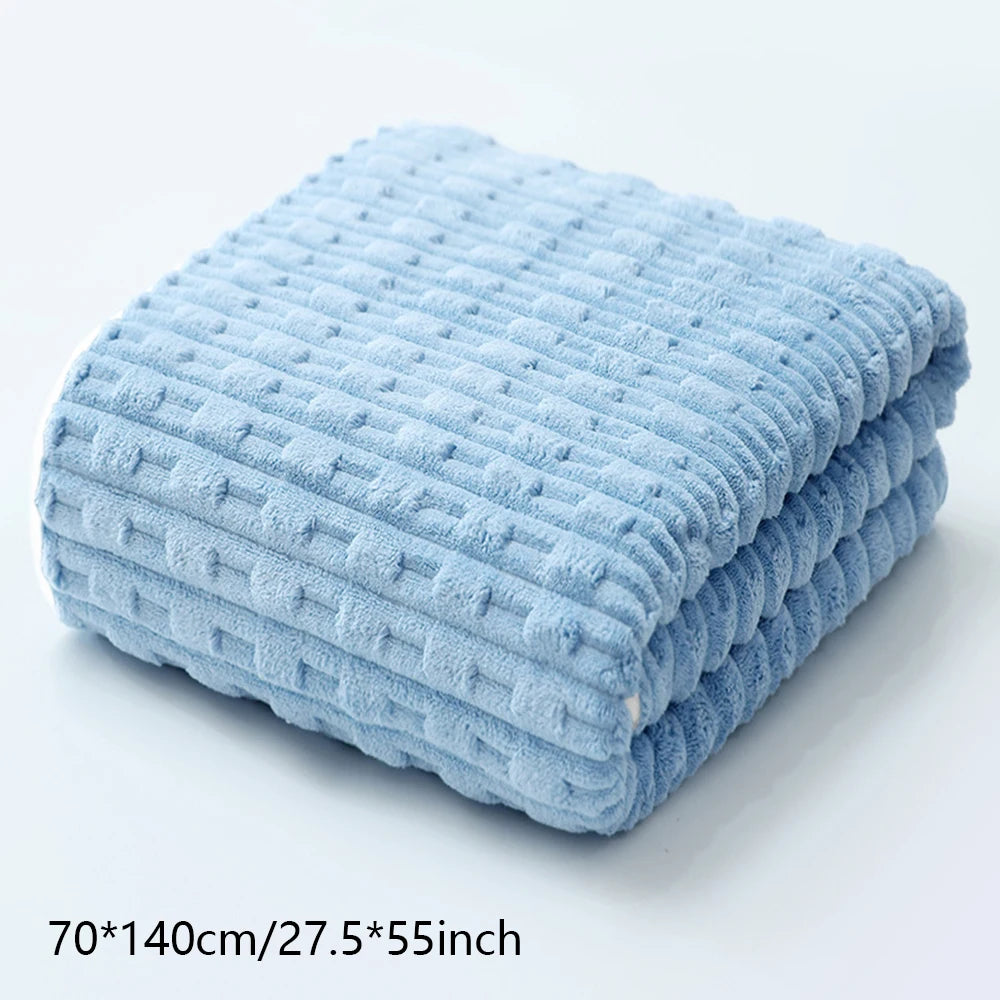 Light blue textured bath towel folded neatly on a white surface