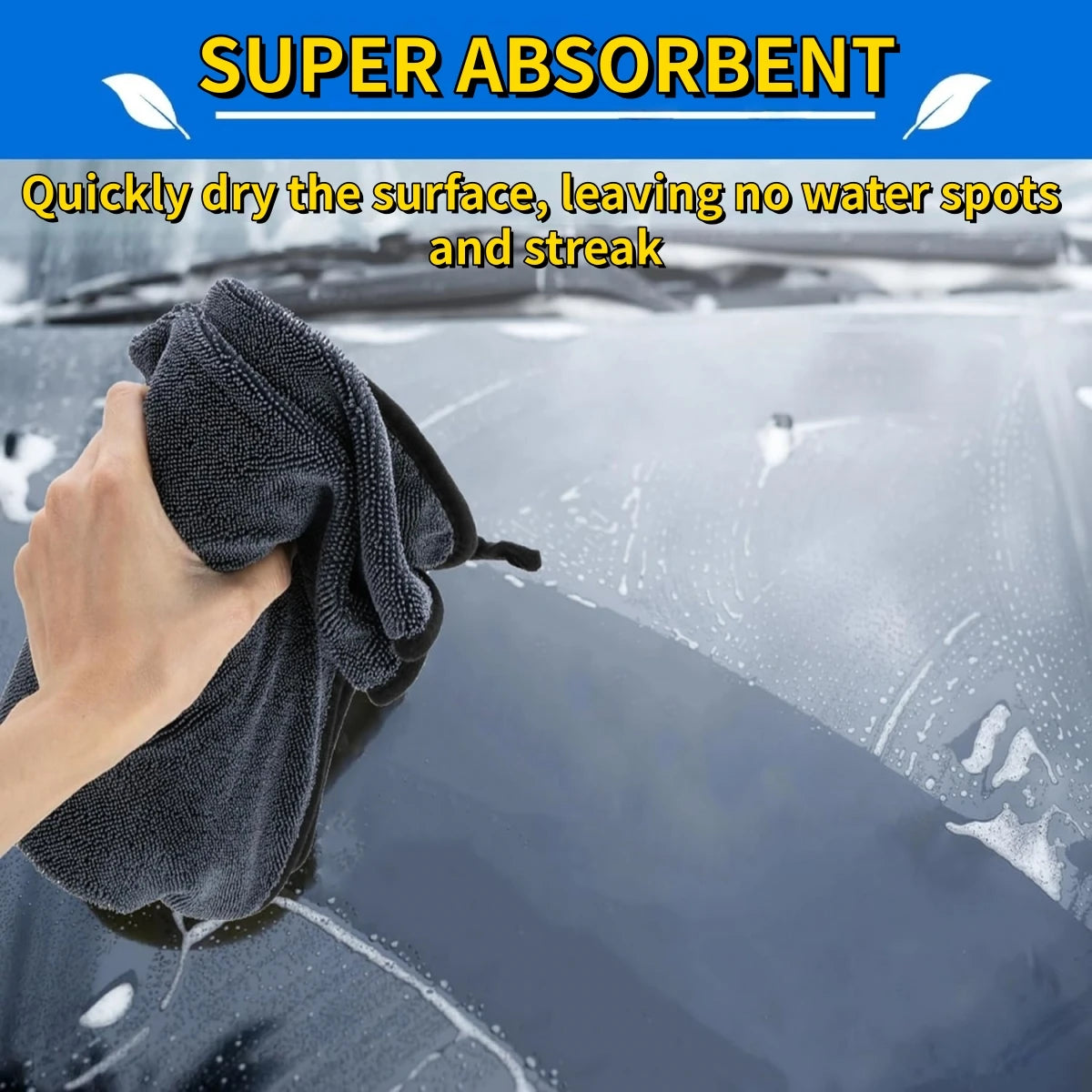A hand is using a dark gray microfiber drying towel to quickly dry a car surface, leaving no water spots or streaks.