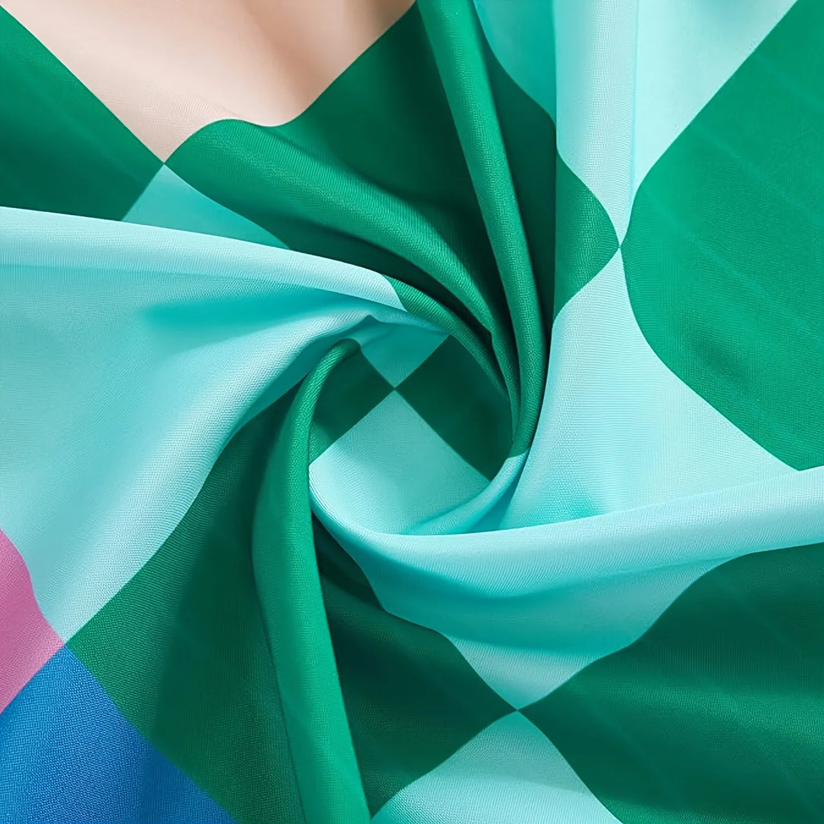Primer plano de tela retro colorida en tonos verde, turquesa y azul, doblada y drapeada.
