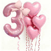 Un set de seis globos de látex en forma de corazón rosa que forman el número tres, atados con cintas rosas.