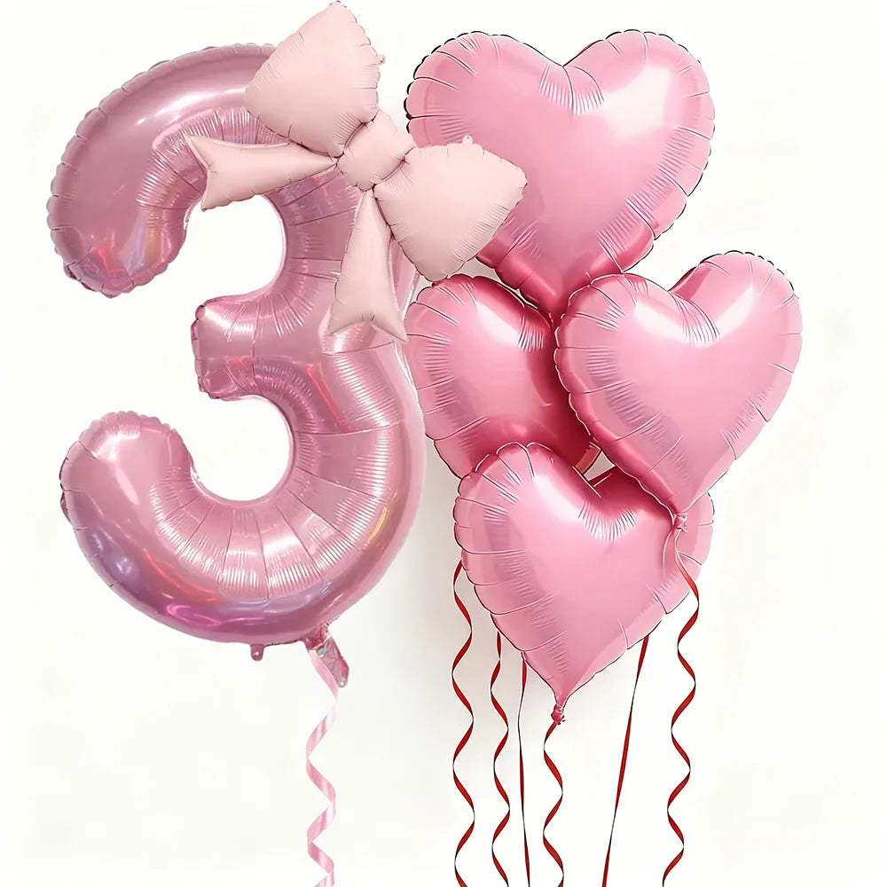 Un set de seis globos de látex en forma de corazón rosa que forman el número tres, atados con cintas rosas.