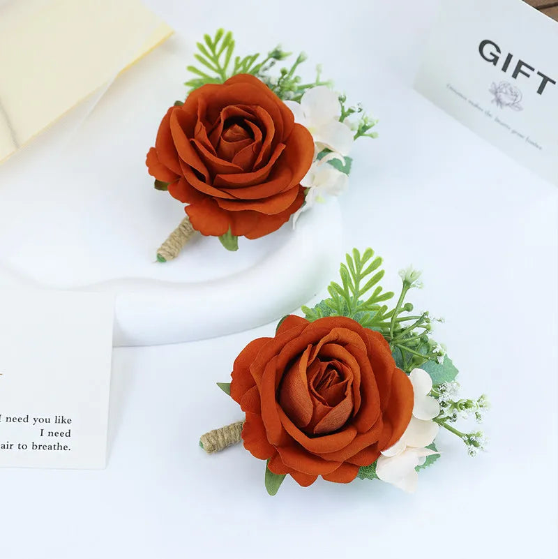 Boutonnière en soie orange vintage avec une rose orange profonde et des accents blancs sur fond clair.