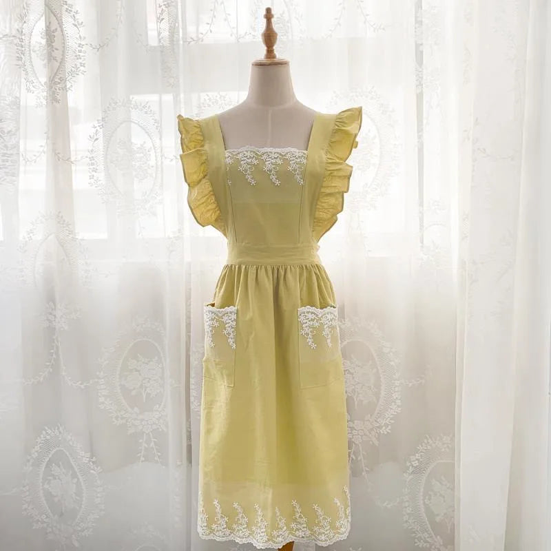 A yellow cotton linen kitchen apron with lace detailing displayed on a mannequin.