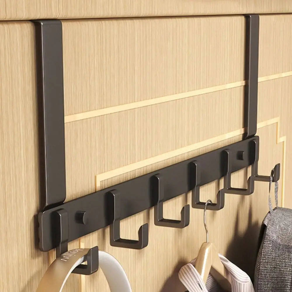 A set of black heavy-duty adhesive door hooks mounted on a light wood-grain surface.