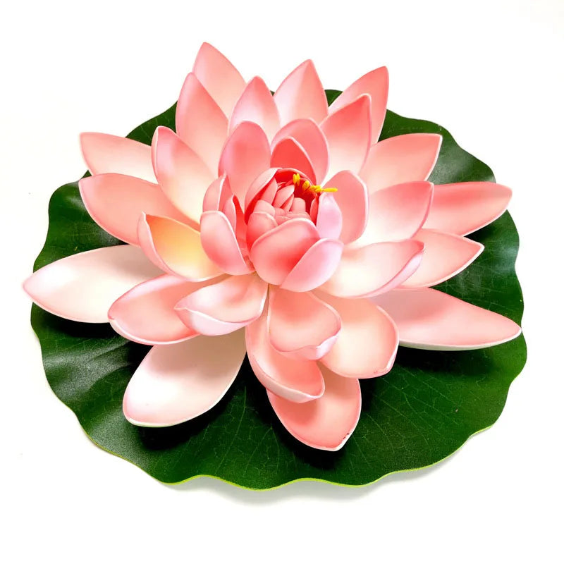 A pink artificial lotus flower blooming on a green leaf.