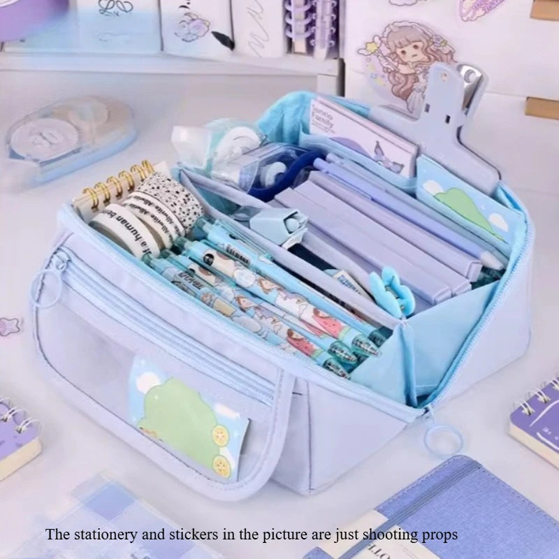 Light blue multi-compartment pencil case organizer filled with stationery and stickers