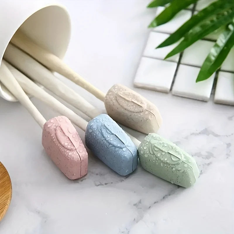 A pack of four pastel-colored toothbrush head covers arranged on a white marble surface.