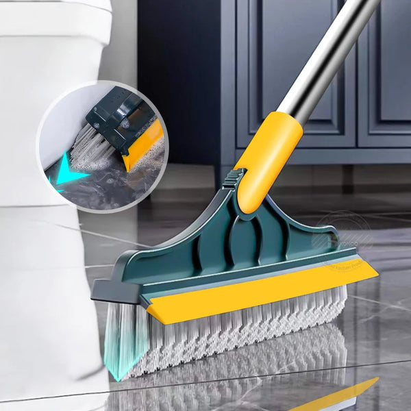 A yellow and teal 2-in-1 floor scrub brush with a metal handle is shown cleaning a tile or hardwood floor.