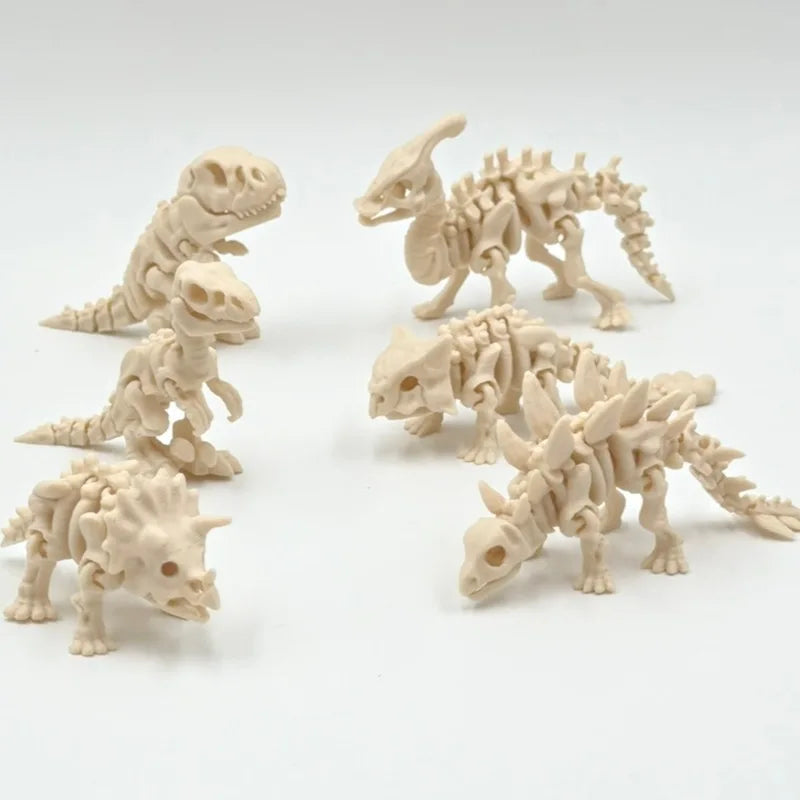 A collection of three small, light beige 3D printed dinosaur skeleton figures arranged on a white surface.