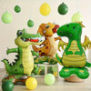 A collection of green and yellow cartoon animal foil balloons, including a dinosaur and a dog, hanging in the air.