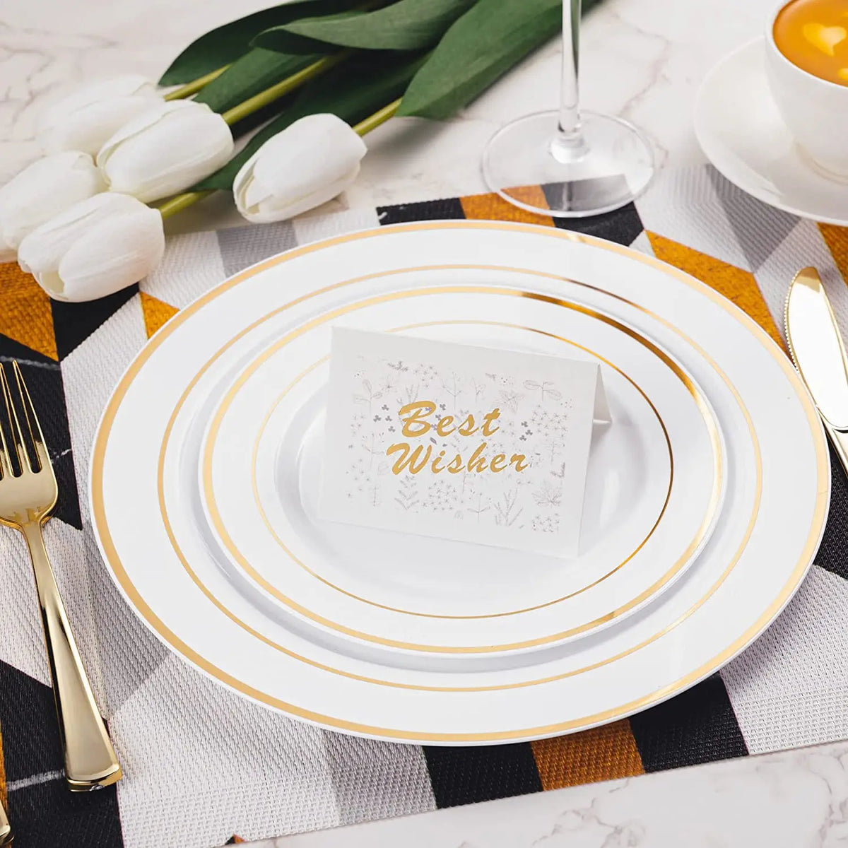Eine Stapel elegante weiße Plastik-Dinnerplatten mit goldenen Rändern, auf einem gestreiften Servietten und umgeben von weiße