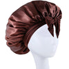 A dark brown silky satin sleep bonnet tied in a bow displayed on a white mannequin head.