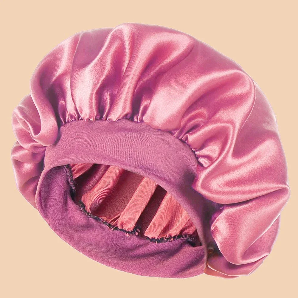 A solid satin wide brim shower cap in a dusty rose color shown from above.