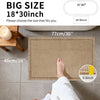 A close-up of a beige waffle weave non-slip bathroom rug being used by a person's foot.