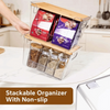 A clear plastic stackable pantry organizer with bamboo lids holding spices and grains on a white countertop.
