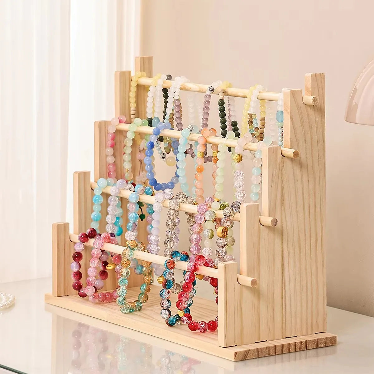 Solid wood ladder jewelry organizer with multiple tiers displaying colorful beaded necklaces