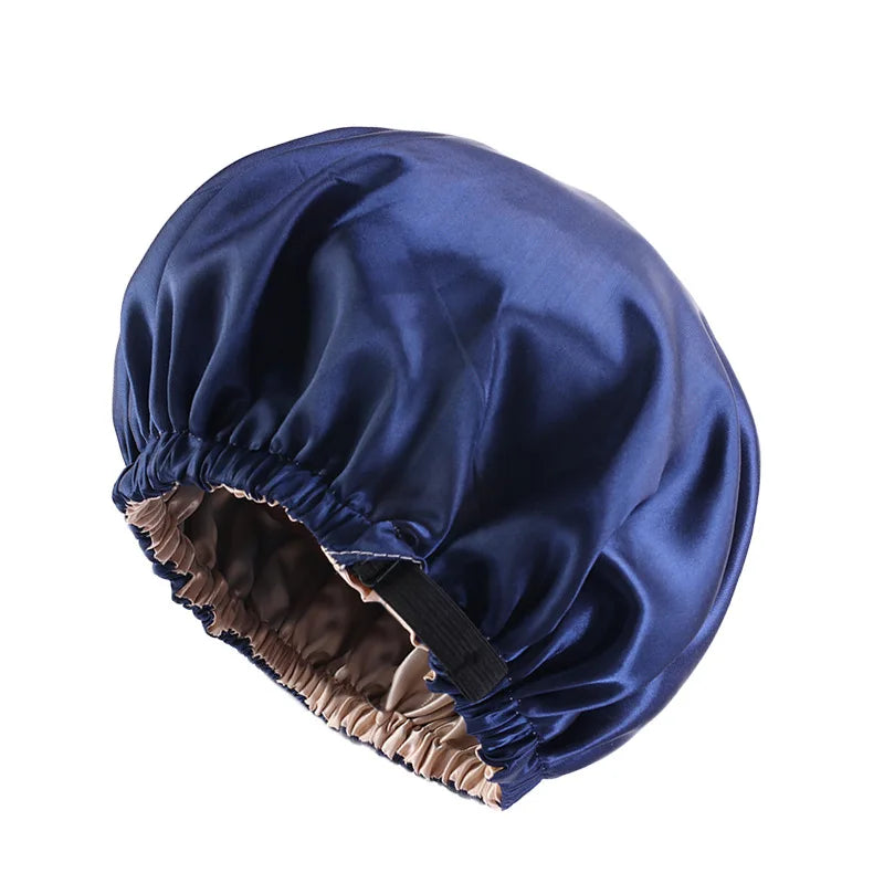 A dark blue satin sleep cap with a gathered brim, designed for curly and natural hair.