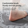 A foot is stepping on a gray silicone mat with textured bumps, demonstrating a comfortable brush sturdy and not prickly surfa
