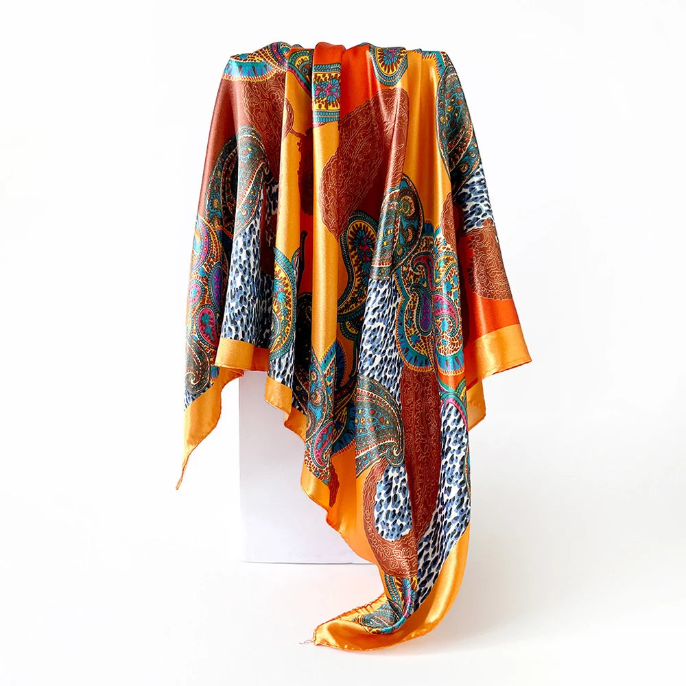 A vibrant orange scarf featuring a paisley print with blue, green, and brown patterns.