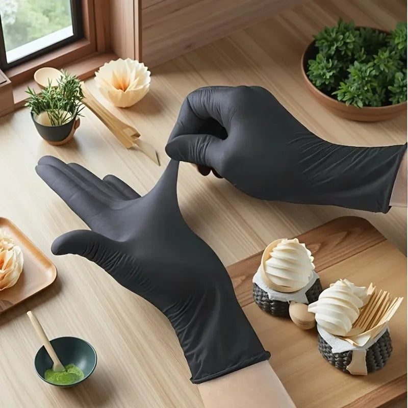 Una mano con un guante de nitrilo negro sostiene alimentos en una mesa de madera.
