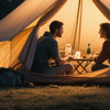 Ein Paar sitzt in einer Zelt neben einem Sonneninsektenvernichter in einer Outdoor-Umgebung.