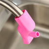 A pink flexible silicone faucet extender attached to a metal faucet, used for easy washing.