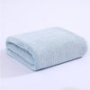 Light blue thickened microfiber bath towel folded and displayed on a white surface.
