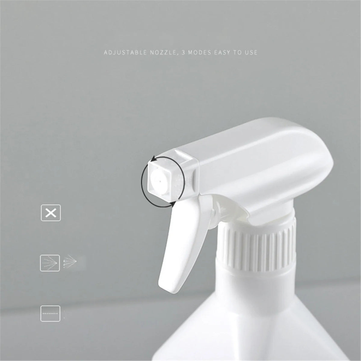 A white refillable plastic spray bottle with an adjustable nozzle is shown against a gray background.