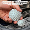 A hand is holding a white concave convex spike sphere product inside a washing machine drum.