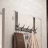 A silver over-the-door organizer rack with multiple extended arms mounted on a white door.