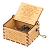 A vintage engraved wooden music box with a lid open, featuring sentimental text inside.