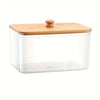 A clear glass container with a wooden lid used for storing dryer sheets.