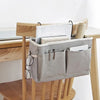 A light gray storage rack with a wooden desk, holding a basket for pens and stationery.