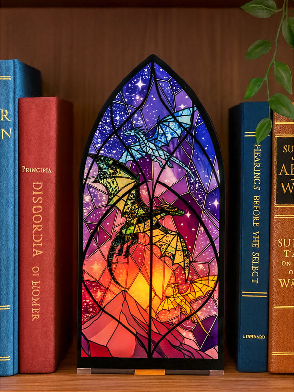A gothic arch dragon candle holder with colorful stained glass design displayed next to books.