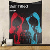 A black tapestry featuring three stylized skulls in red, black, and blue tones.