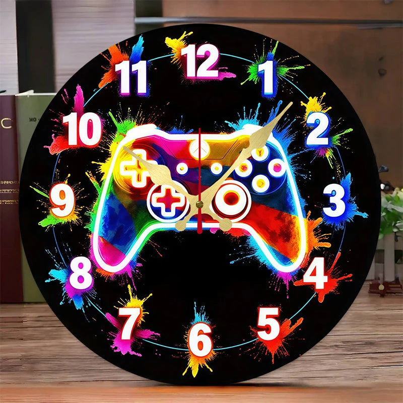 Reloj de pared redondo negro con arte pixelado colorido de un control de videojuegos y los números del 1 al 12.