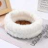 A white microfiber wrist sweatband set for face washing and skincare is shown on a light surface.