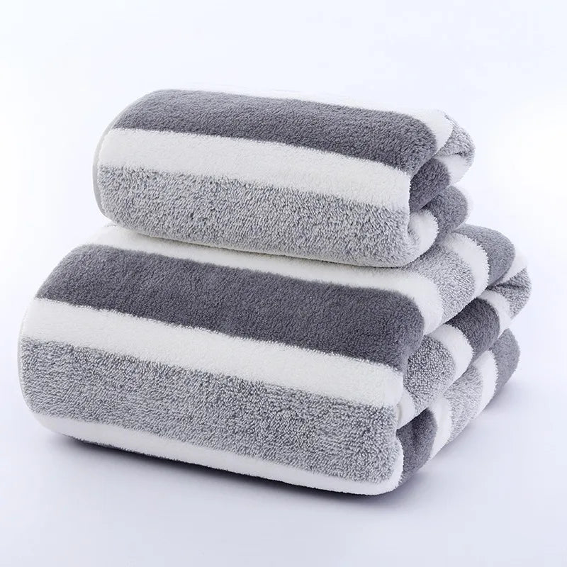 A stack of gray and white striped microfiber bath towels rolled neatly.