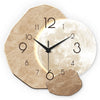 Horloge murale moderne avec motif de lune, fond beige texturé et aiguilles noires.