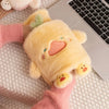 A yellow plush animal hot water bottle is resting on a white laptop keyboard and pink knitted fabric.