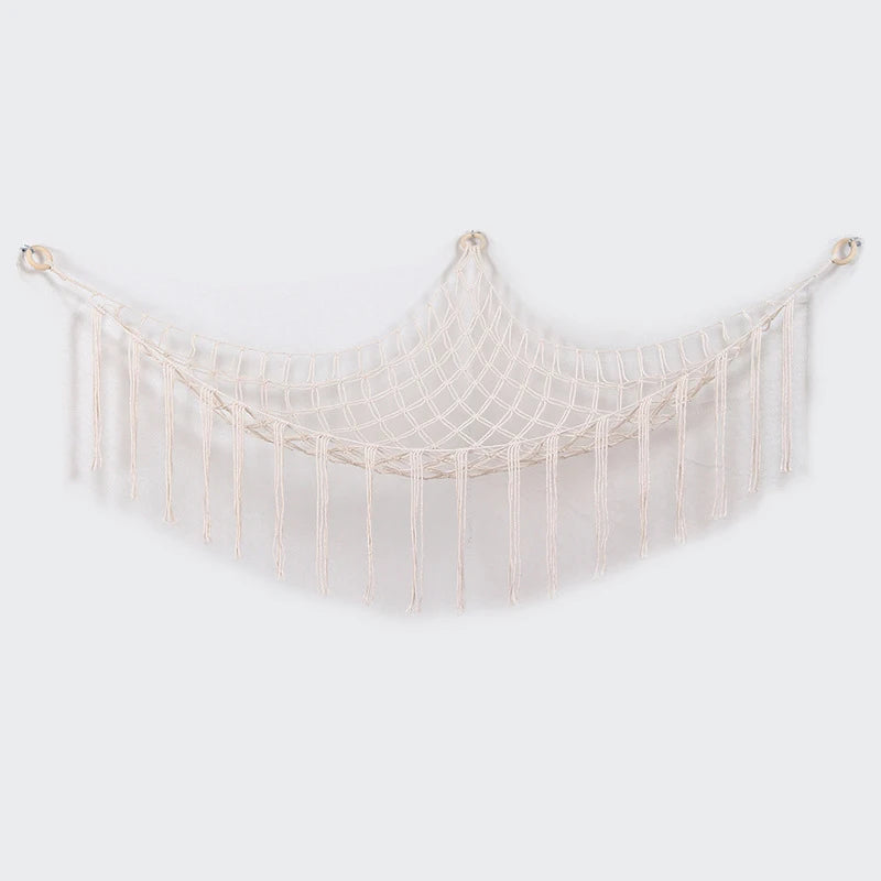 A beige plush animal hammock storage net with fringe details.