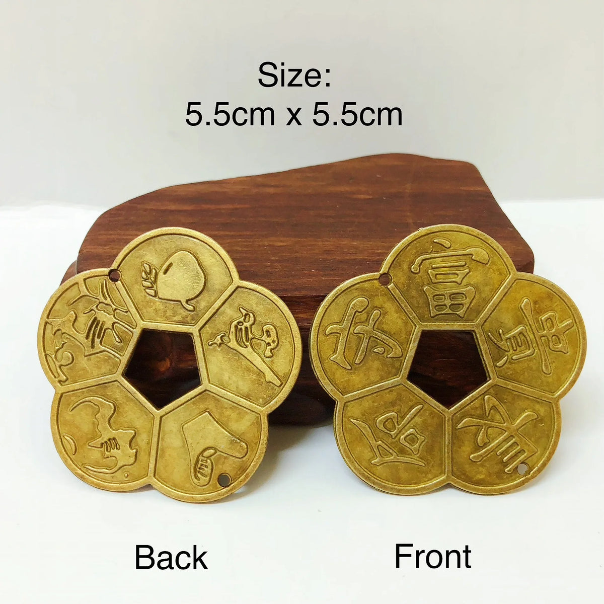 Traditional copper feng shui coins showing the back and front designs on a wooden surface
